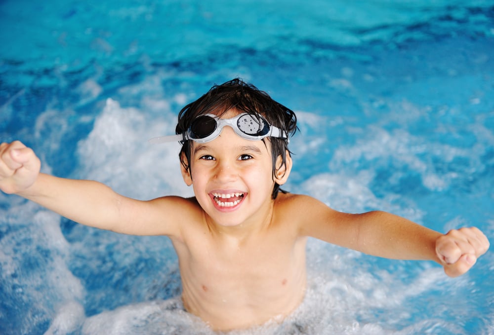 Little cute  boy in blue water of the swimming pool, summer time for fun